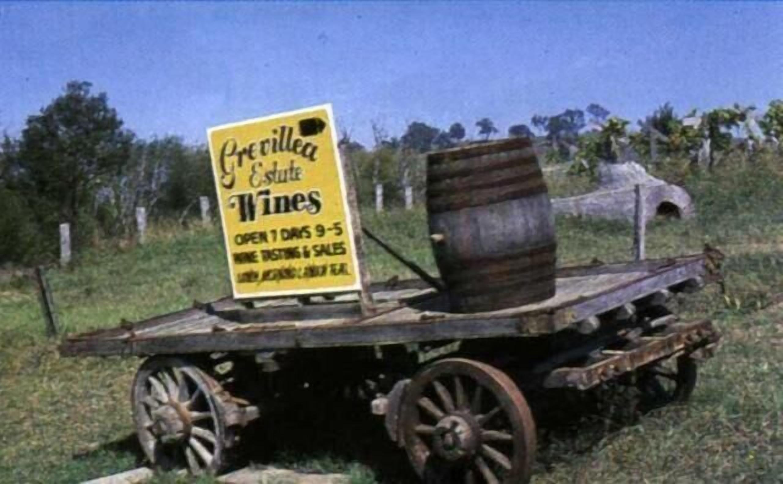 A vintage wine cart with a sign advertising 'Previlla Estate Wines' open 1 day 9-5.