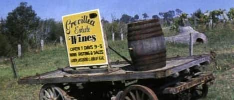 Carro de vinos antiguos con un cartel que anuncia 'Previlla Estate Wines', abierto 1 día de 9 a 5.