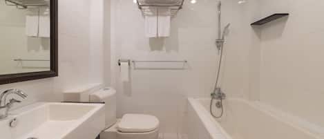 Un baño moderno con lavamanos, inodoro y bañera blancos. Hay barras para toallas sobre el inodoro y la bañera.