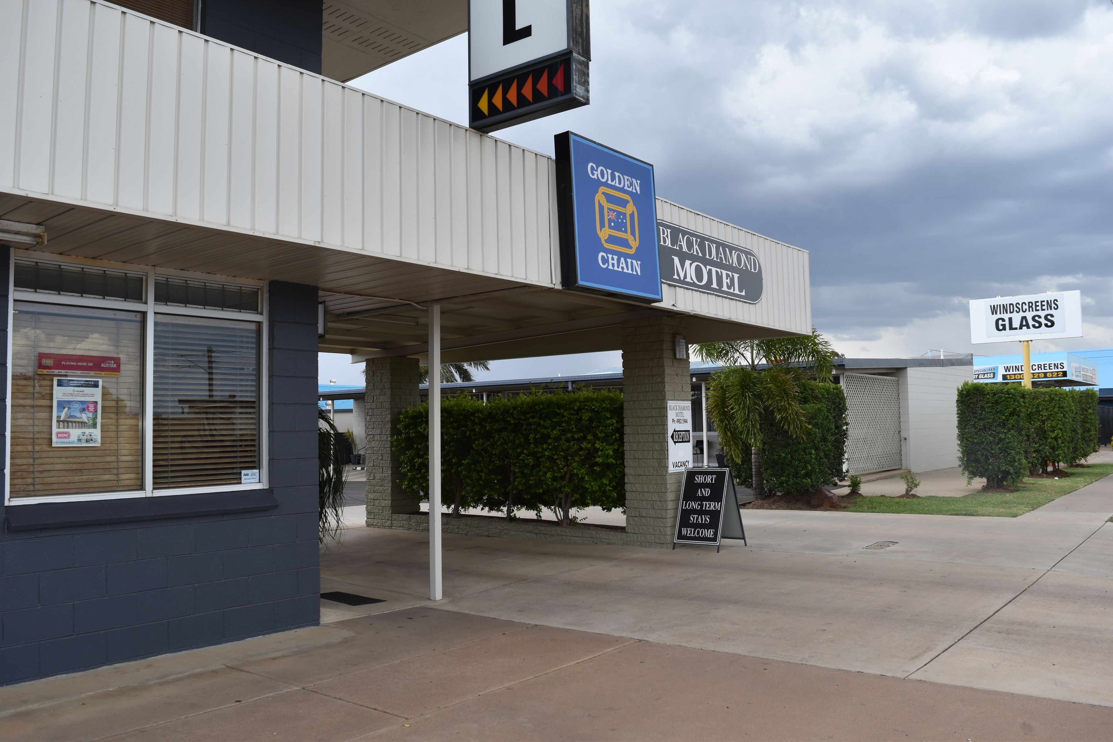 A motel with a sign for the Golden Chain and Black Diamond Motel.