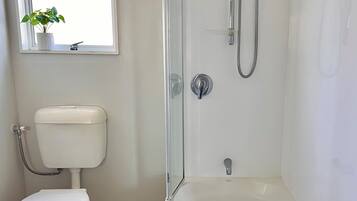 Un baño con inodoro, cabina de ducha y bañera.