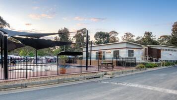 Een buitenzwembad, ligstoelen bij het zwembad