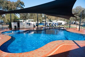 Una piscina al aire libre, sillones reclinables de piscina