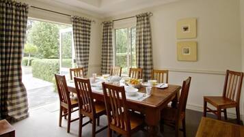 Comedor con una mesa de madera dispuesta para seis personas, rodeada por seis sillas de madera.