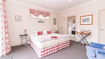 A bedroom with a bed, bedside table, and a desk with a chair.