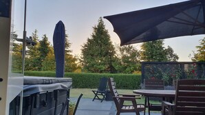 An outdoor patio area with a grill, seating, and a large umbrella. - Ruapehu Country Lodge (Ohakune)