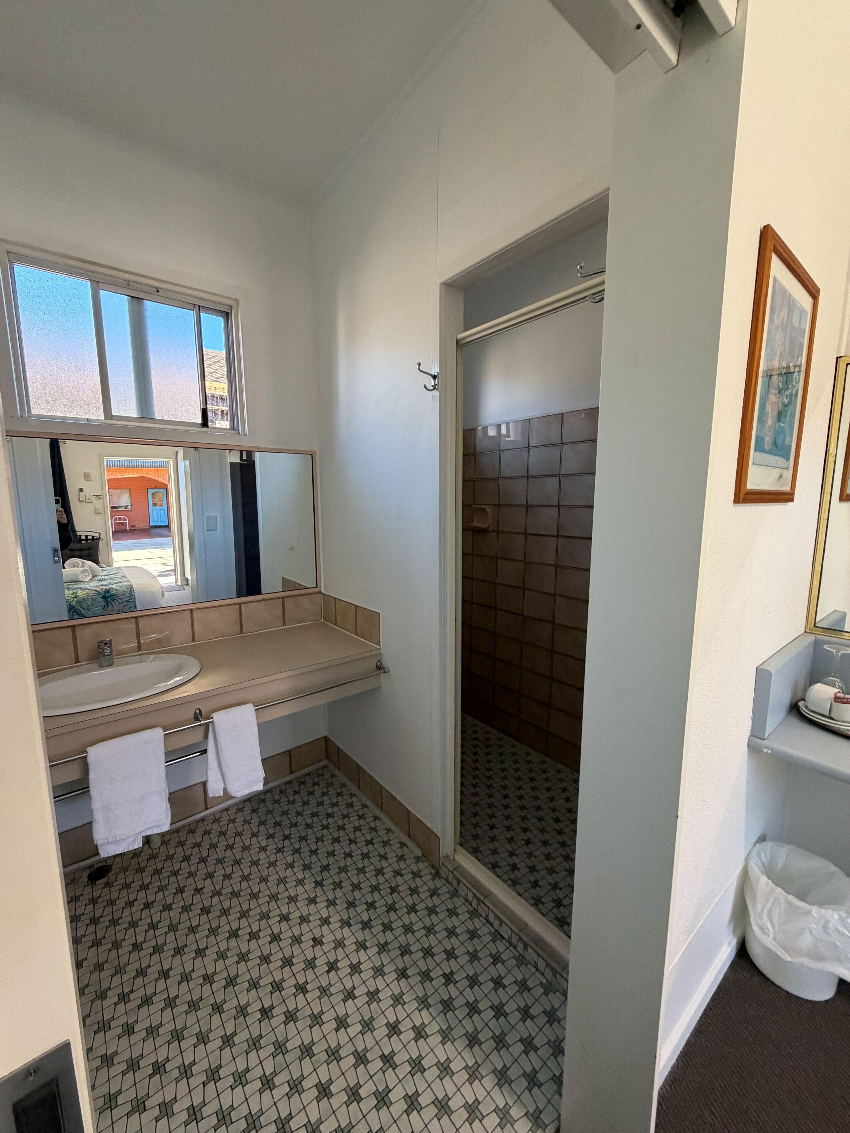 Un baño con lavamanos, espejo y ducha.