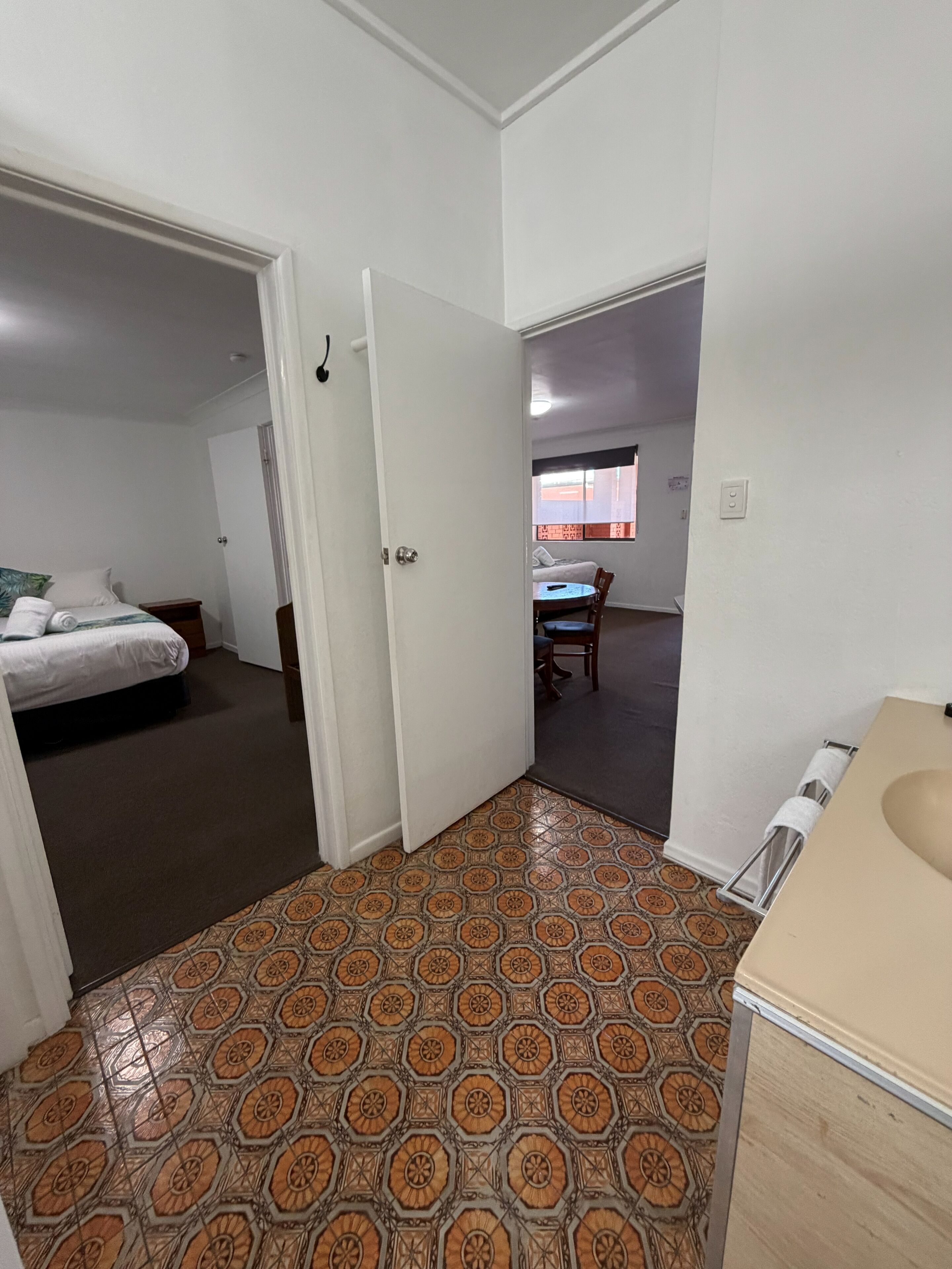 A room with a bed, a desk, and a bathroom.