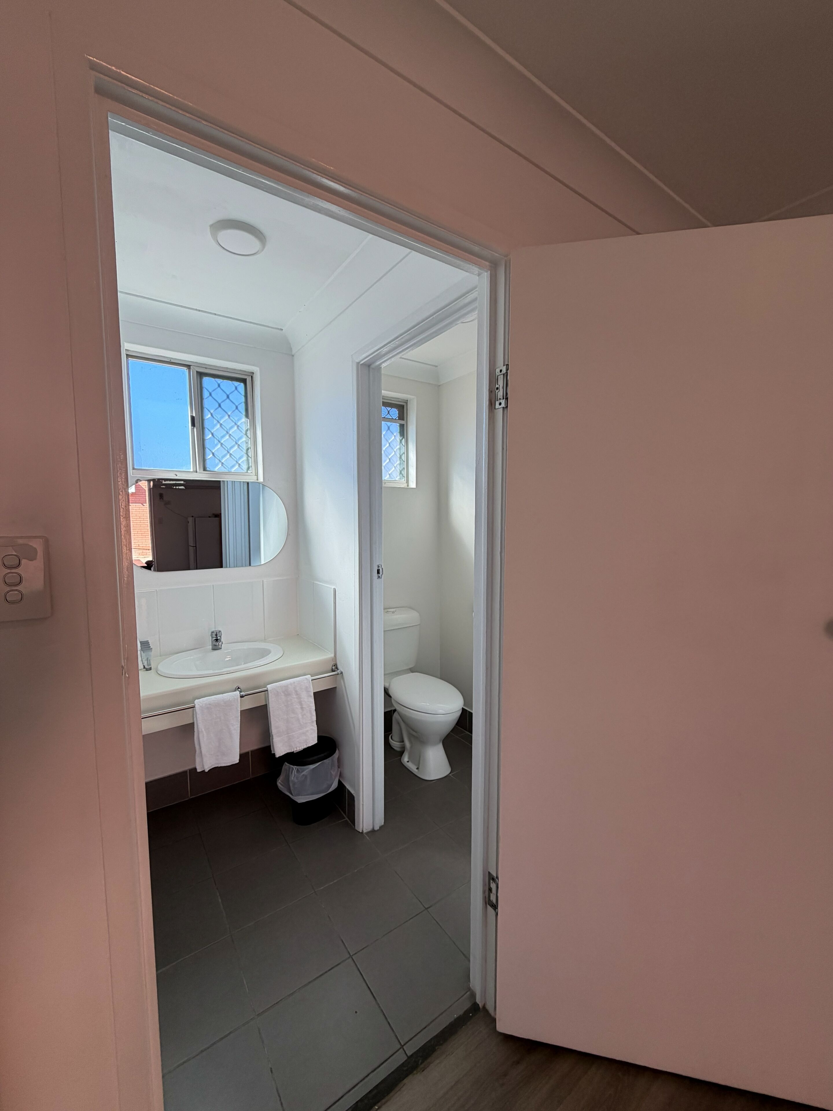 Ein Badezimmer mit Waschbecken, Spiegel und Toilette.