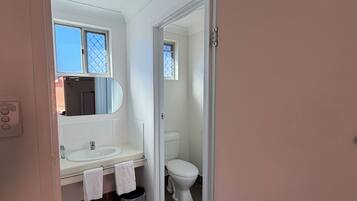 Ein Badezimmer mit Waschbecken, Spiegel und Toilette.
