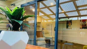 Un intérieur moderne avec une table en bois, une plante en pot et une cloison en verre.