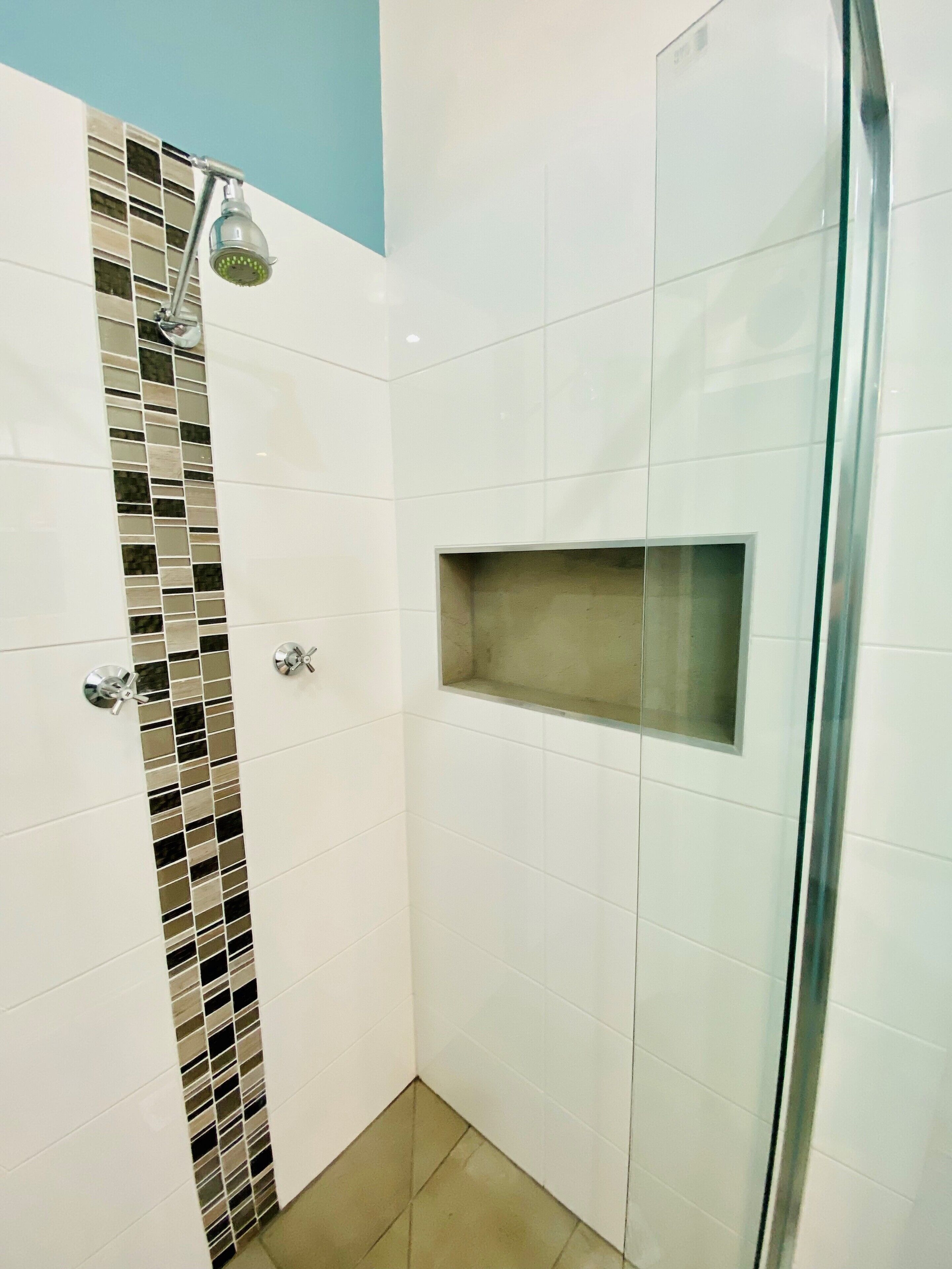 A small, enclosed shower area with a glass door and a showerhead.