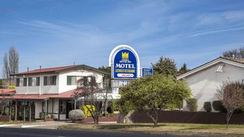 A motel with a red roof, a white exterior, and a blue sign indicating a licensed restaurant.