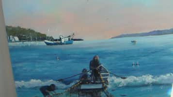 A painting of a coastal scene with boats and fishing nets.
