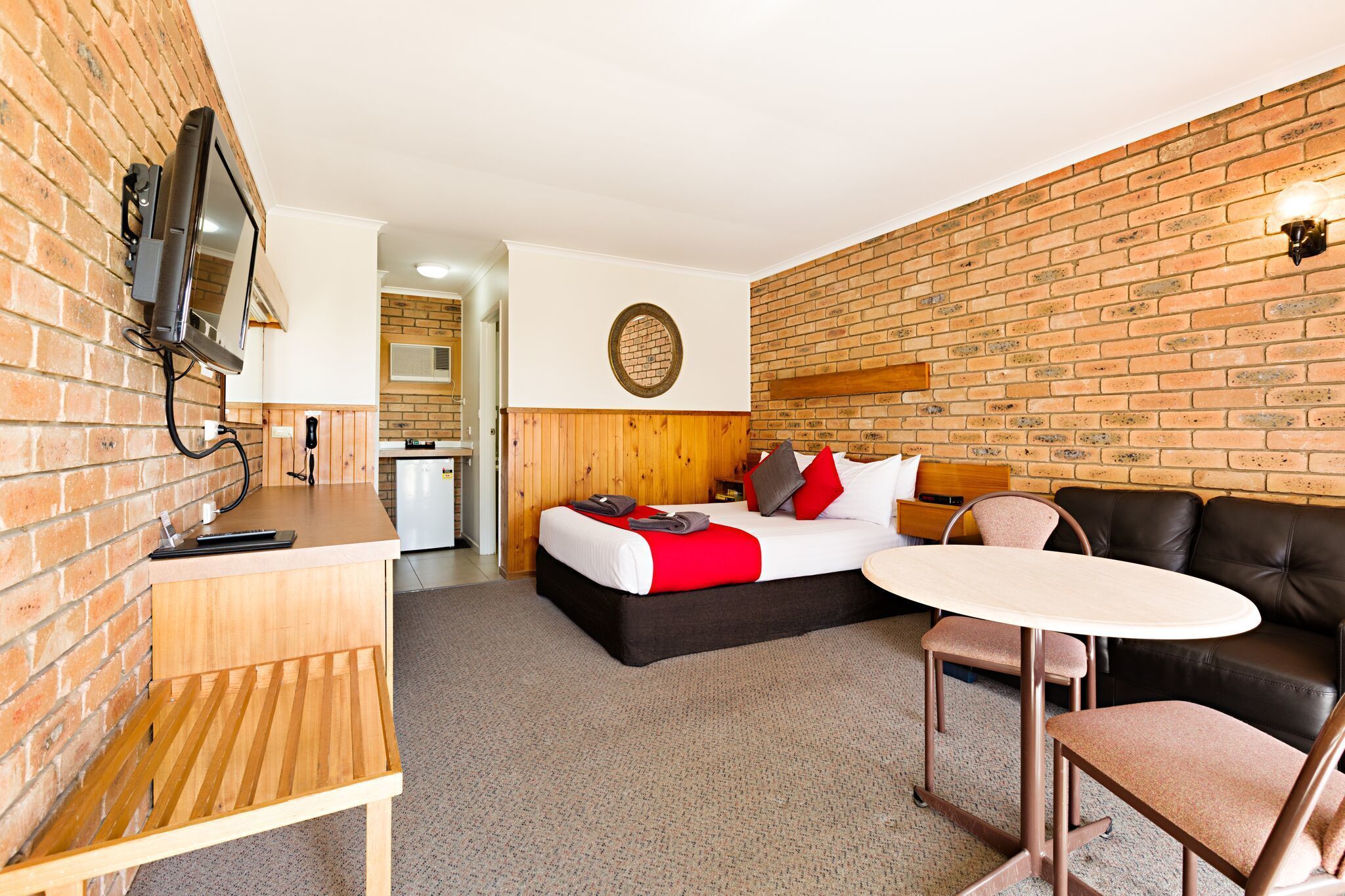 A room with a bed, a desk, a table, and a couch.