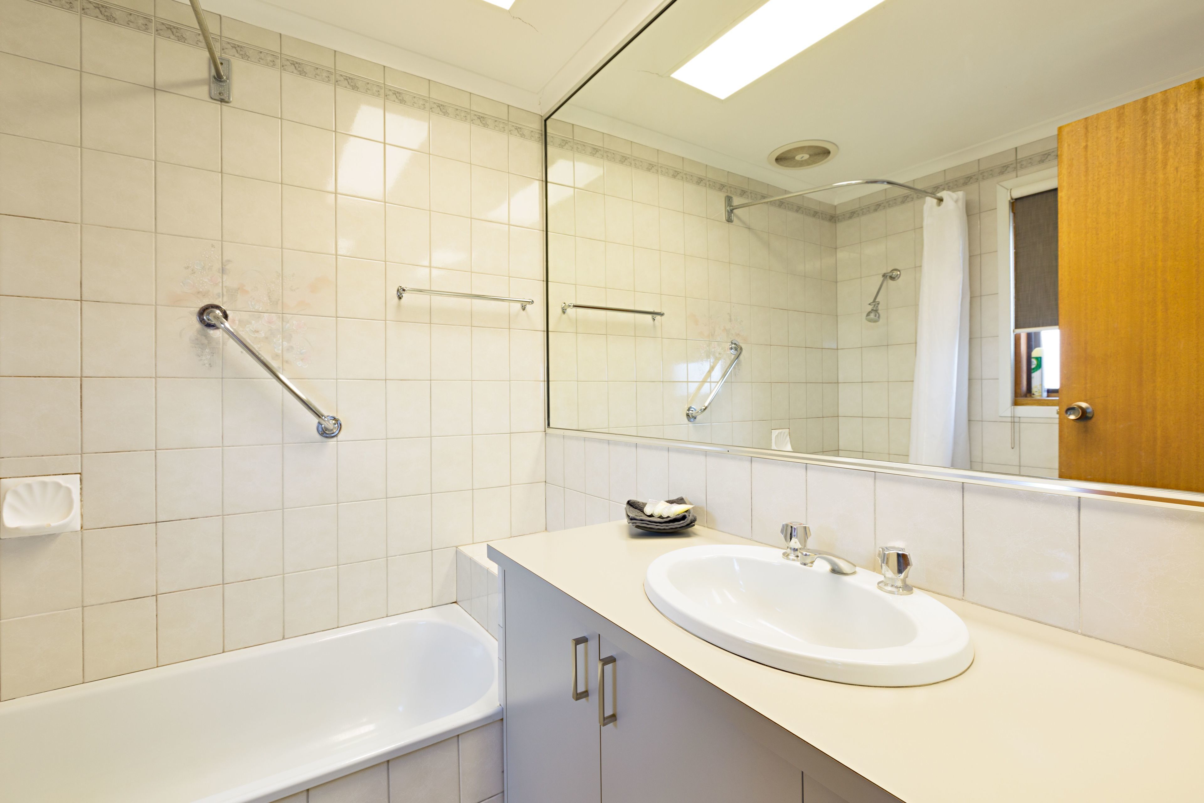 Un baño con bañera, lavamanos, ducha y espejo.