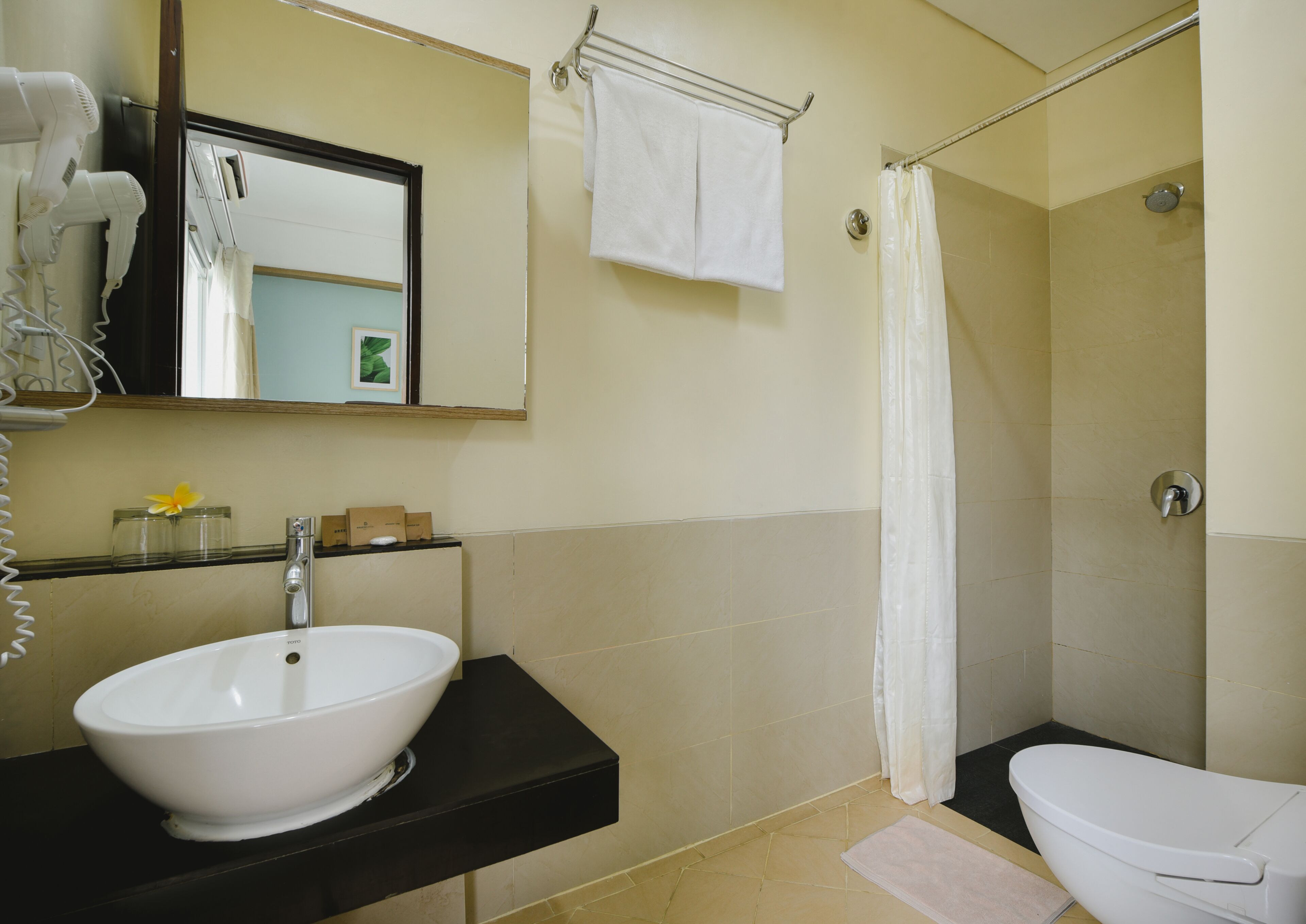A bathroom with a sink, toilet, and shower curtain.