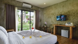 Une chambre d’hôtel équipée d’un lit, d’une télévision, d’un bureau et d’un petit réfrigérateur.