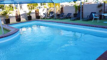 Piscina a l'aire lliure, para-sols i gandules
