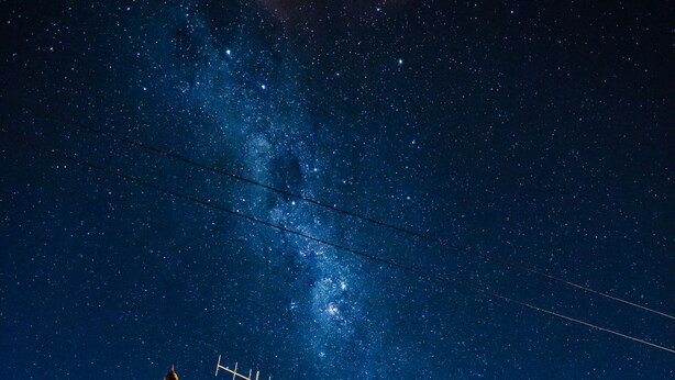 A house with a stone chimney, wooden exterior, and a satellite dish. - Inn the Bay Bed & Breakfast (Kaikoura)