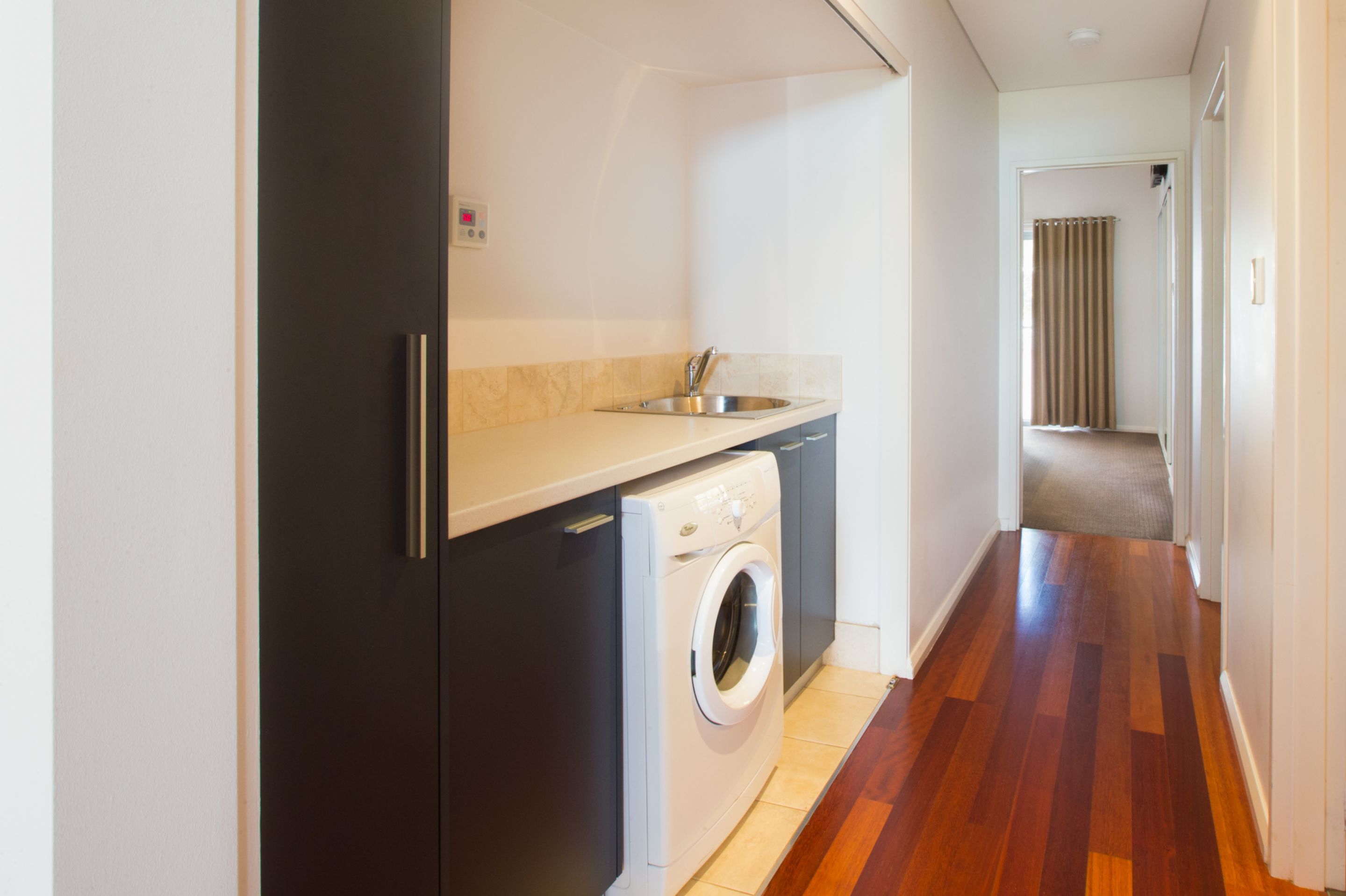 A compact kitchen with a built-in washing machine, a sink, and a countertop.