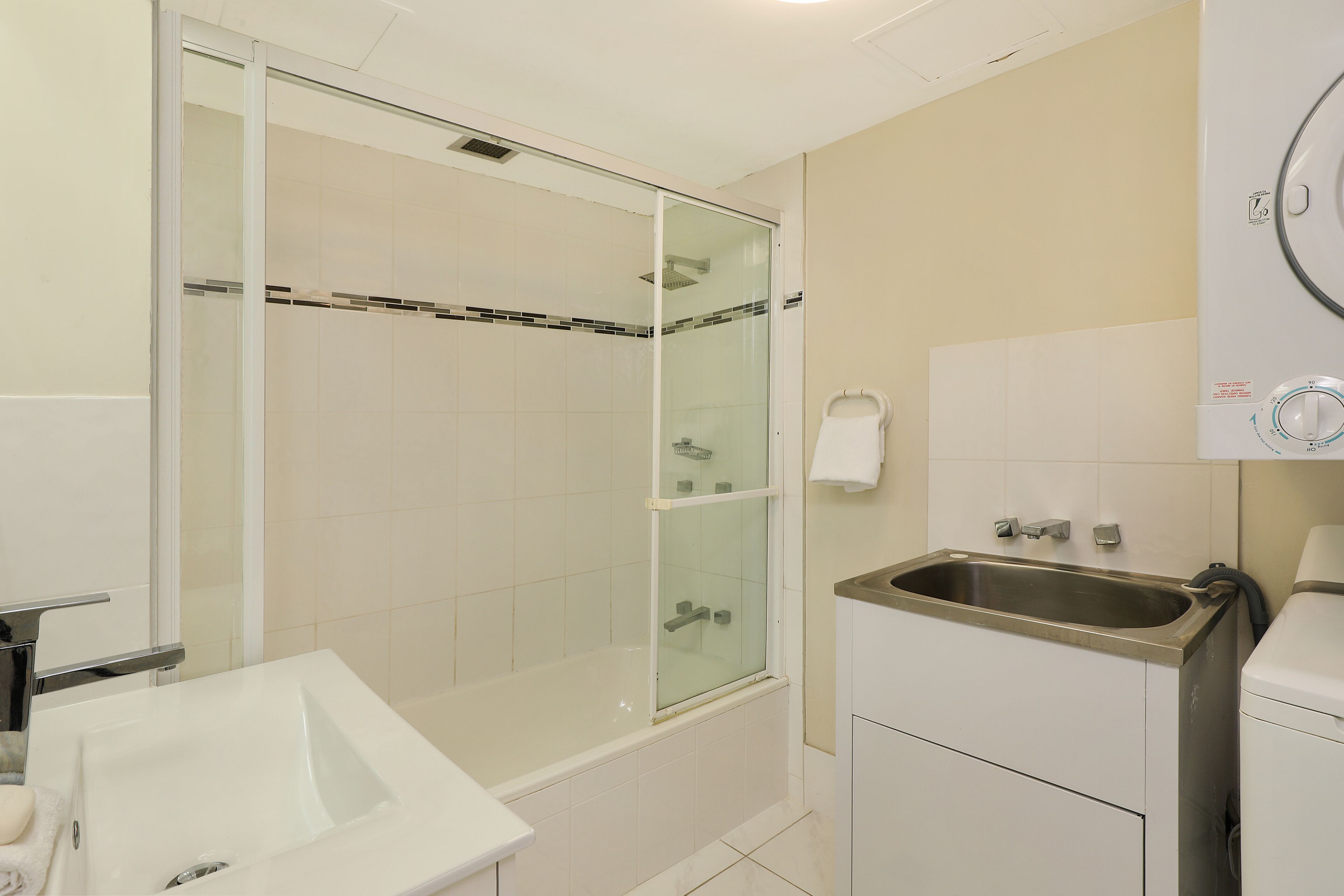 A bathroom with a glass-enclosed shower, a sink, and a toilet.