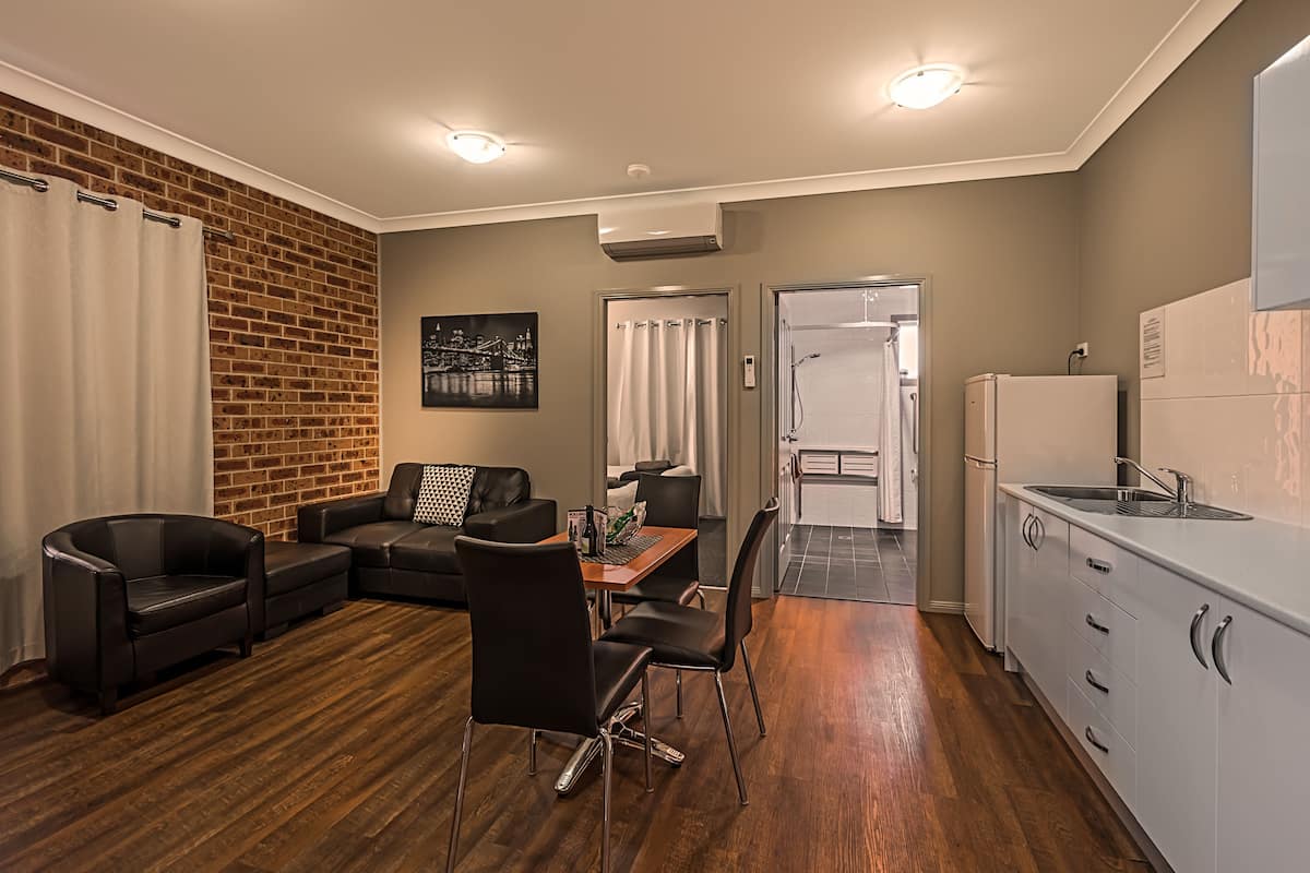 A modern apartment with a dining area, kitchen, and living room.