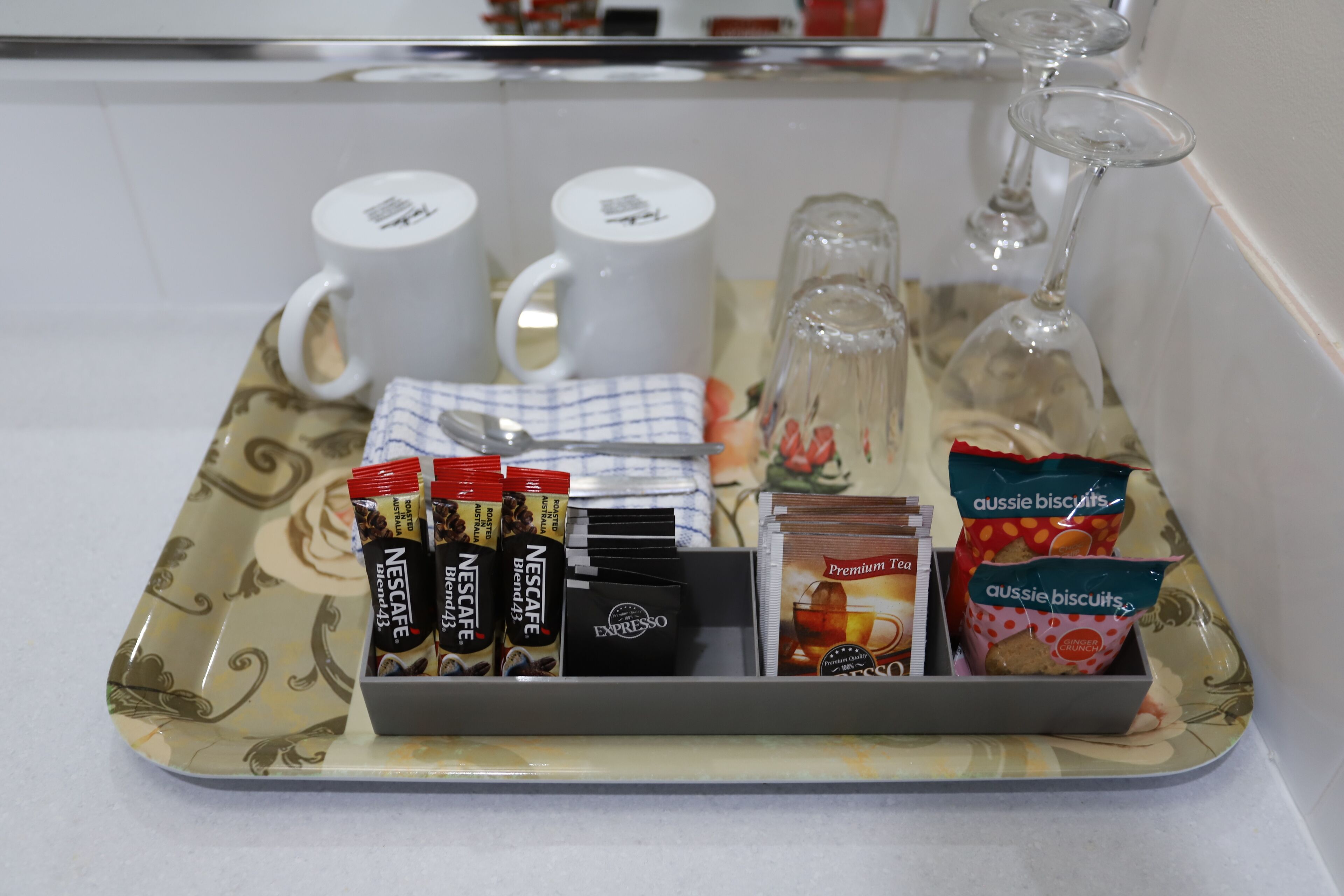 A tray with coffee pods, tea bags, and biscuits.