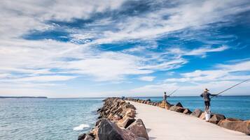 A pier extending into calm waters with a clear sky.