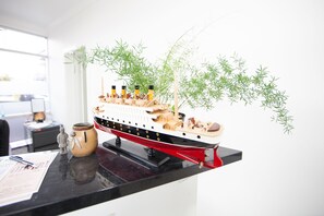 A model ship on a desk with a vase and a figurine. - Ballina Hi Craft Motel (Ballina)