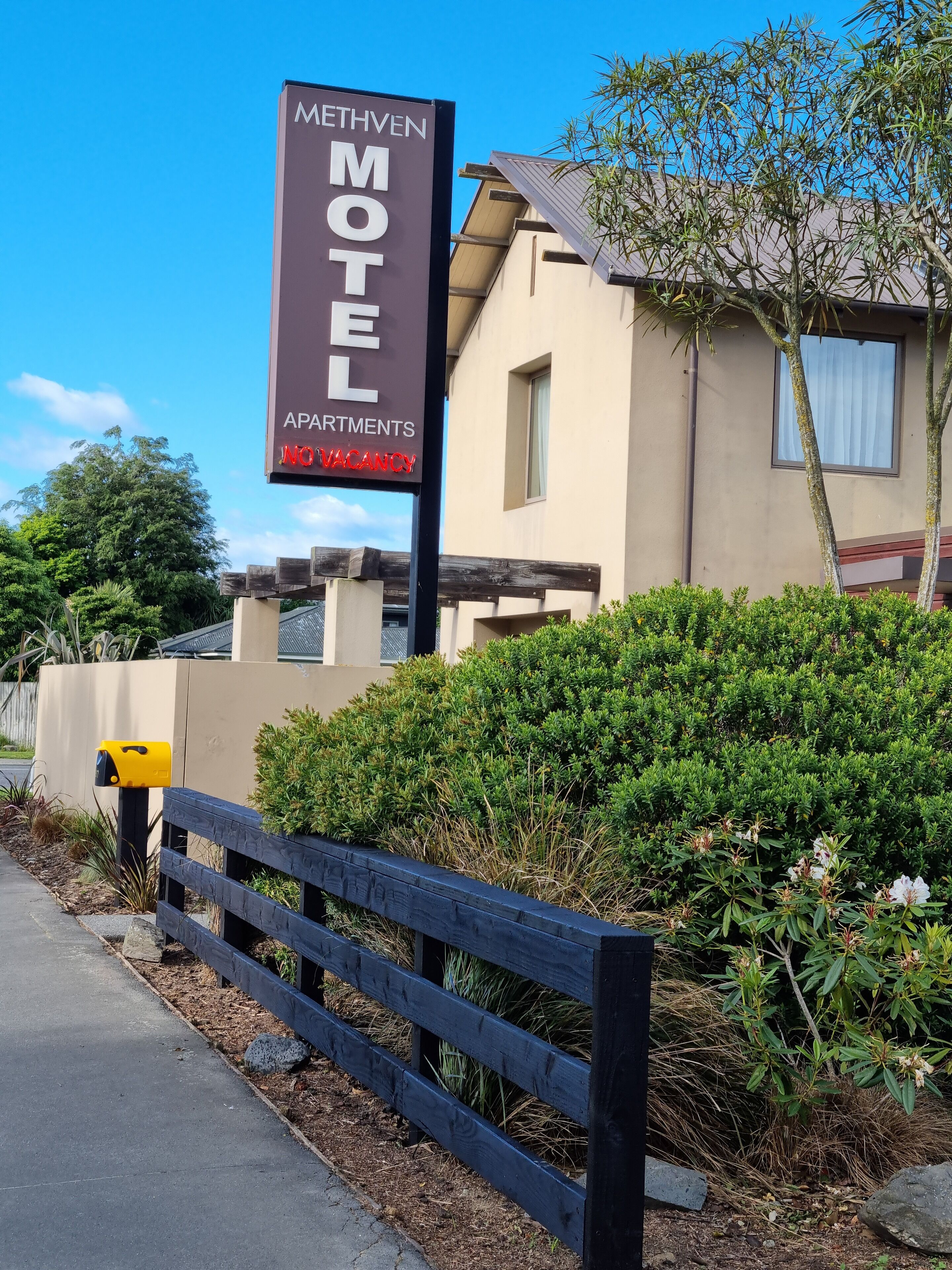 A motel sign with "METHVEN MOTELO" and "APARTMENTS NO VACANCY" written on it.