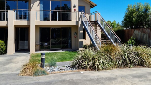 A two-story house with a balcony, a satellite dish, and a staircase leading to the second floor. - Methven Motels & Apartments (Methven)