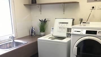 A laundry area with a washing machine, dryer, and a sink.