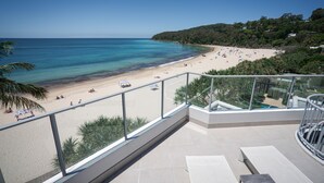 Un balcon avec vue sur une plage et l’océan.