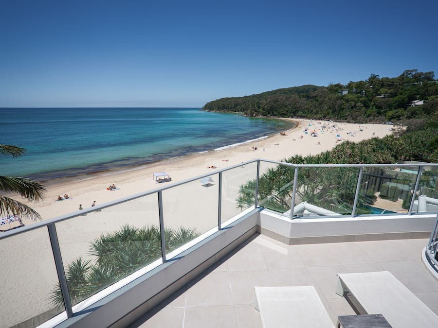 Ein Balkon mit Blick auf Strand und Meer.