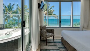 Une chambre avec une grande fenêtre, un lit, une chaise et une baignoire.