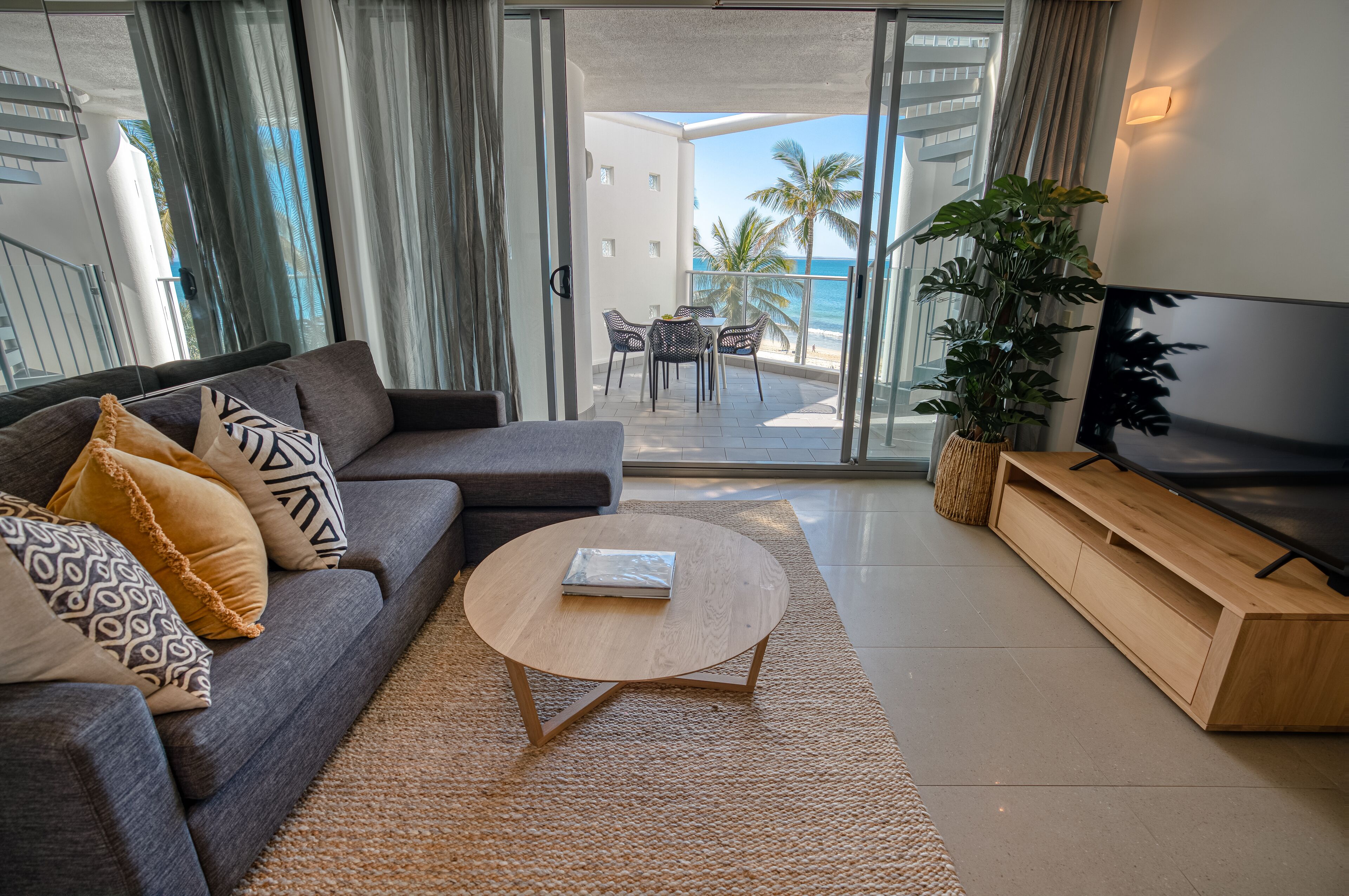 A modern living room with a sofa, coffee table, and TV stand.
