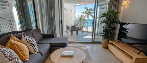 A modern living room with a sofa, coffee table, and TV stand.