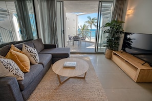 Beachfront Spa Studio Penthouse | Living room | Flat-screen TV, DVD player - On The Beach Noosa (Noosa Heads)