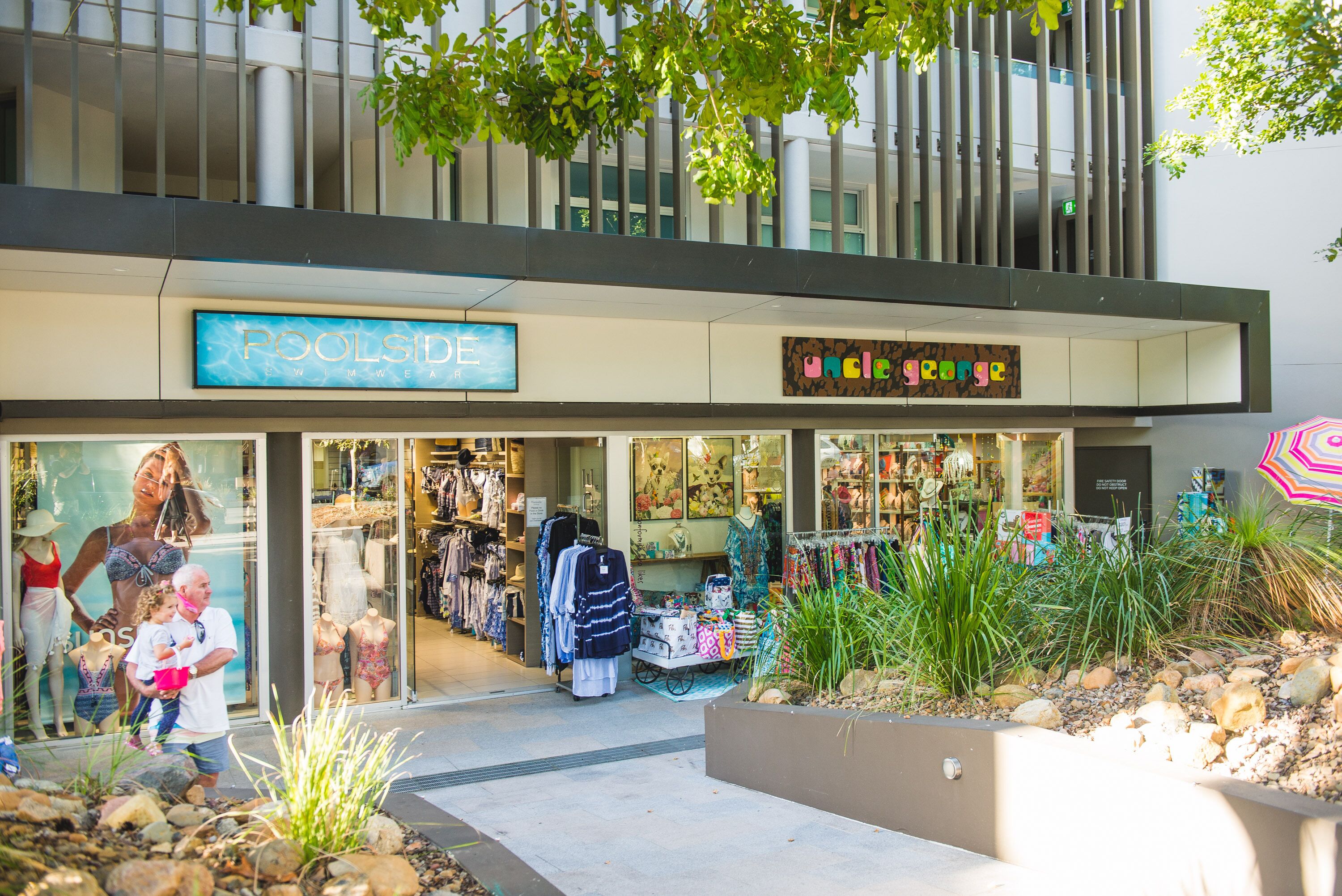 A storefront with a sign for 'Poolside' and 'Uncle George' clothing stores.