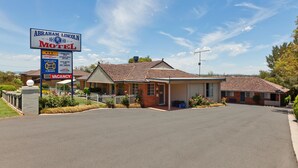 A motel with a signboard, a covered parking area, and a brick building. - Abraham Lincoln Motel (East Tamworth)