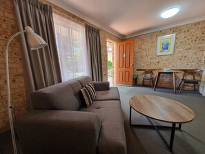 Rom – executive, 1 queensize-seng, massasjebadekar, hageområde (Deluxe Spa Suite) | Oppholdsområde | En 24-tommers Flatskjerm-TV med kabel-kanaler samt TV