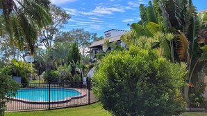 A swimming pool surrounded by lush greenery and a building labeled "TOWER COURT." - Tower Court Motel (Torquay)