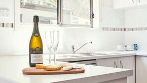 Eine moderne Küche mit einer Weinflasche, Gläsern und Käse auf der Arbeitsplatte.