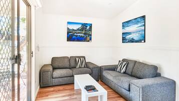 Cabaña Deluxe, 2 habitaciones | Área de sala de estar | Televisión de pantalla plana y tenis de mesa