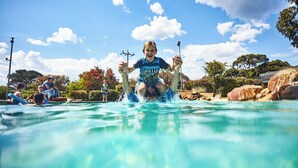 Ein Poolbereich mit klarem Wasser, umgeben von Felsen und Bäumen.