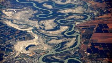 An aerial view of a mining area with winding water channels and industrial structures.