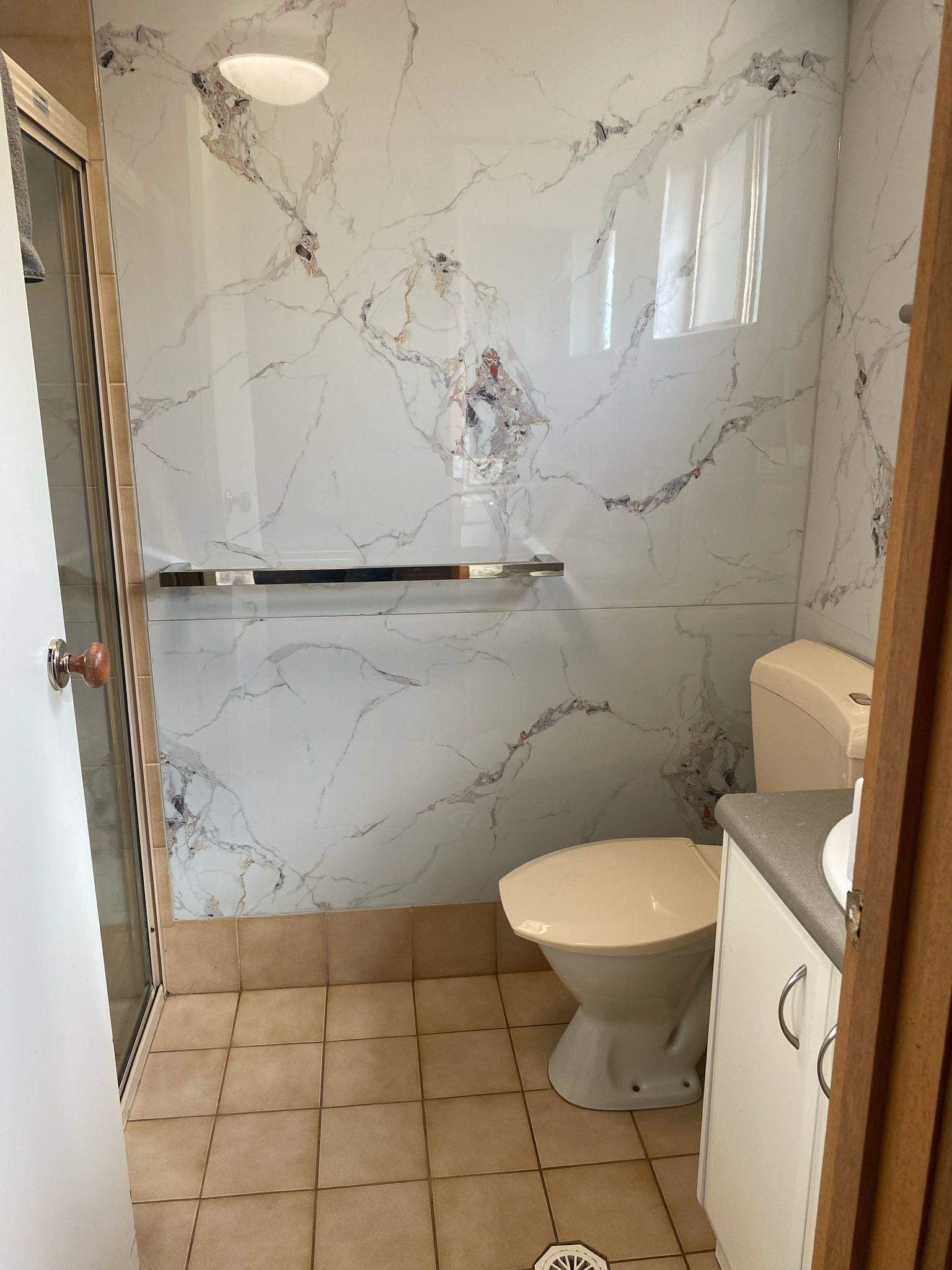 Een badkamer met toilet, wastafel en douche.