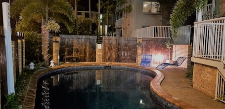 Una piscina al aire libre, sillones reclinables de piscina