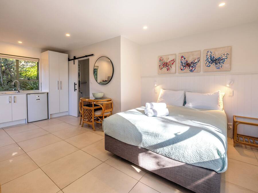 A bedroom with a bed, bedside table, and a window.